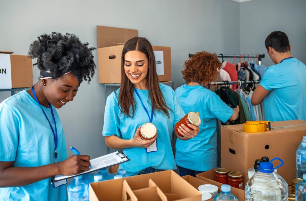 Social workers at homeless shelters helping prep food and clothes in the back.