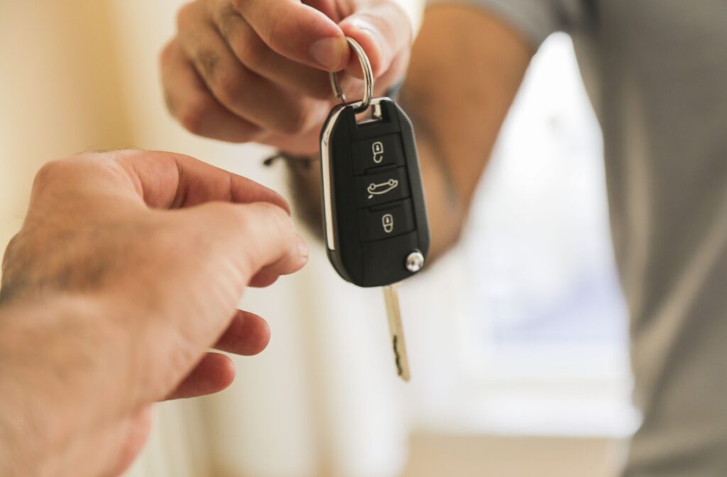 A close-up a man's hand who is about to receive a car key.