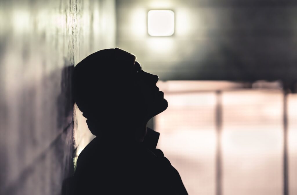 A silhouette of a man experiencing homelessness.