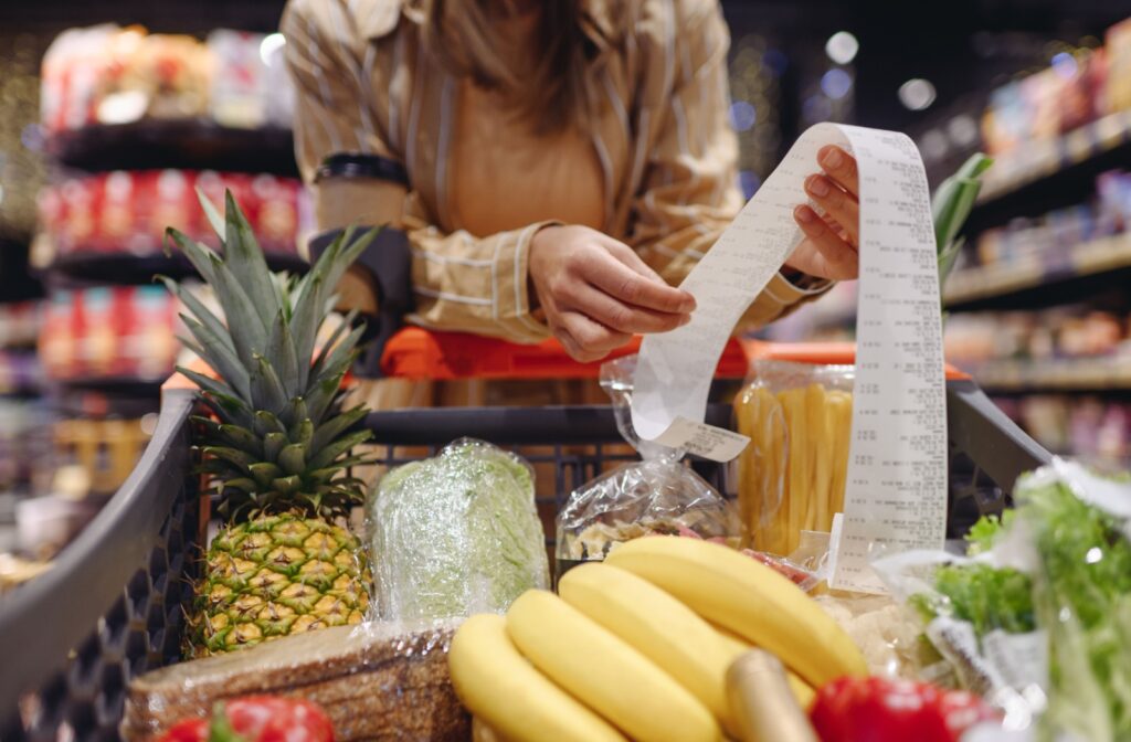 A person reviewing their grocery bill in Canada, reflecting on the rising cost of food.