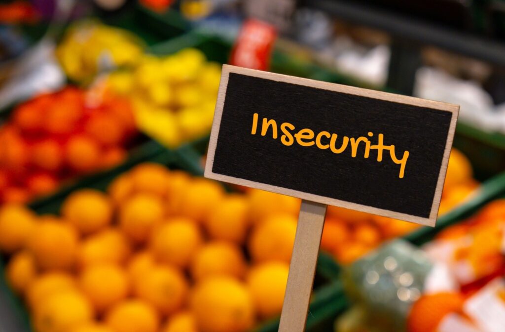 A sign that reads "insecurity" in a produce section at a grocery store